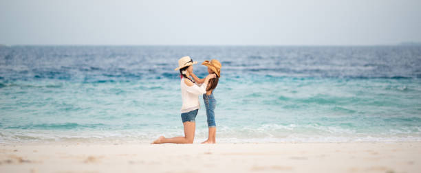 istock Mother and daughter playing on the beach 1204008705