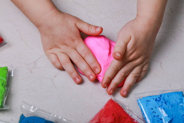 istock baby crumples pink plasticine with his hands 1204009240