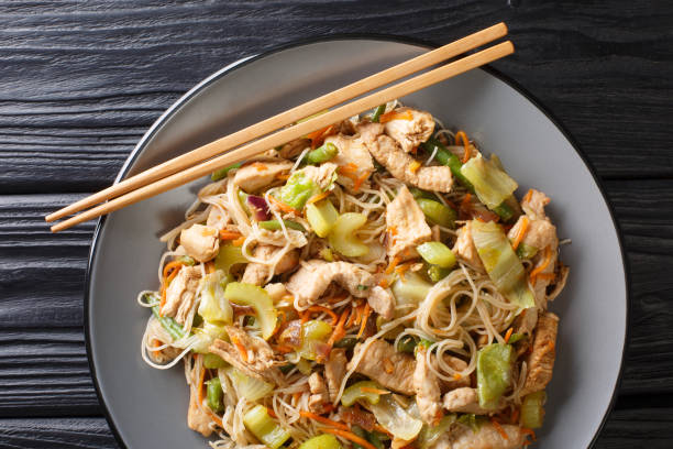istock stir fried rice noodles pancit bihon with vegetables and meat close-up in a plate. Horizontal top view 1204009331