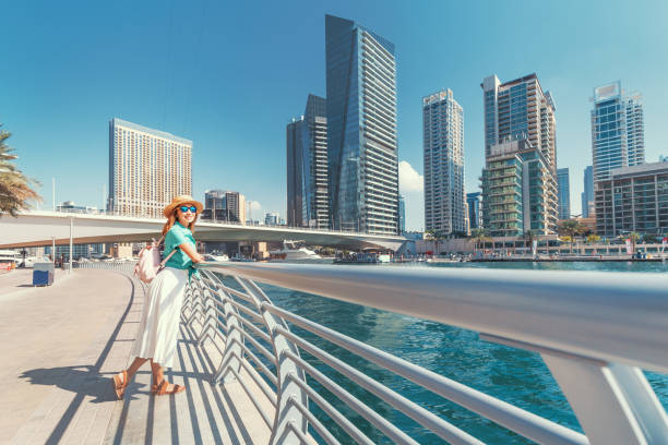 glücklich asiatische mädchen zu fuß auf einer promenade in dubai marina bezirk. reisen und lifestyle in vereinigte arabische emirate - united arab emirates dubai marina asia arabia stock-fotos und bilder