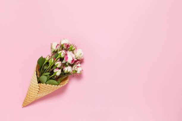 istock Small roses in waffle cone on pink background, copy space. Minimal style flat lay. For greeting card, invitation. March 8, February 14, birthday, Valentine's, Mother's, Women's day concept. Top view 1204009675