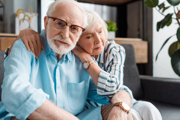 istock Selective focus of senior man looking at camera by wife on couch 1204011440