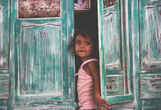 Beautiful girl hanging out on window. Healthy childhood.
