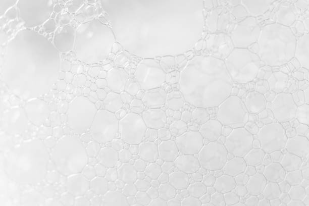 Soap or shampoo foam texture with selective focus, close-up. Macro bubbles white background