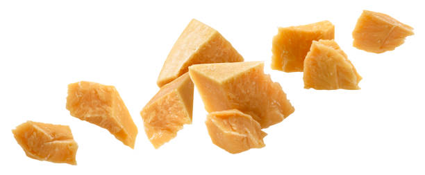Falling broken pieces of parmesan cheese isolated on white background
