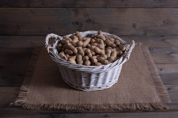 istock groundnuts on a wooden table in a basket. 1204016757