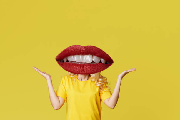istock Modern art collage. Womans body with red lips as a head on yellow background 1204018080