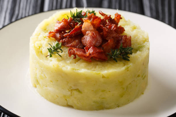 istock Trinxat Spanish and Andorran dish spicy mashed potato cabbage topped with fried bacon closeup in a plate. horizontal 1204019258