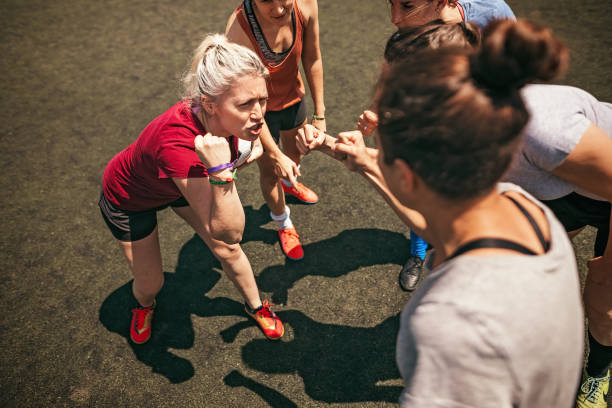 Female soccer team huddling and shouting