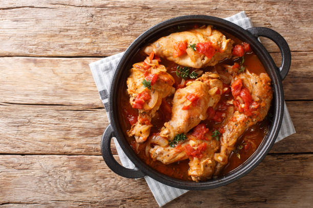 savoureux ragoût de lapin épicé dans la sauce tomate avec le vin blanc et les herbes plan rapprochés dans une casserole. vue supérieure horizontale - lapin viande de gibier photos et images de collection