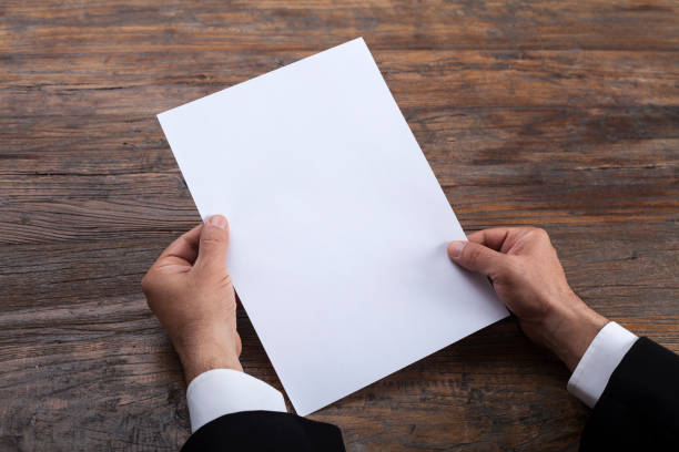 istock Person holding white empty paper 1204021753