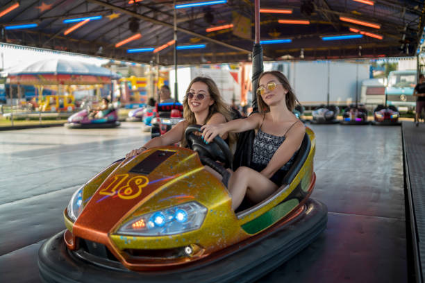 istock Happy girlfriends driving a bumper car and smiling 1204022786