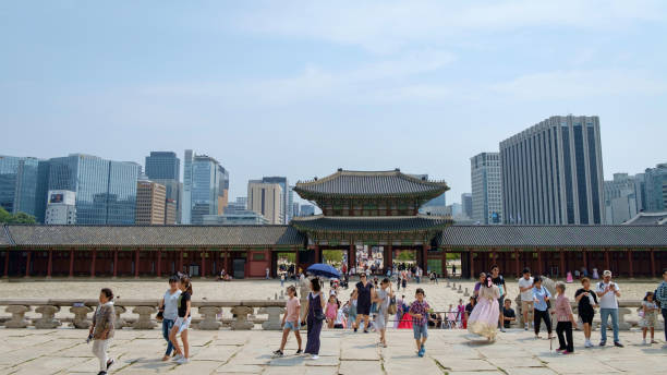 palais historique de gyeongbokgung avec des bâtiments modernes à l'arrière. - gyeongbokgung palace stone palace monument photos et images de collection