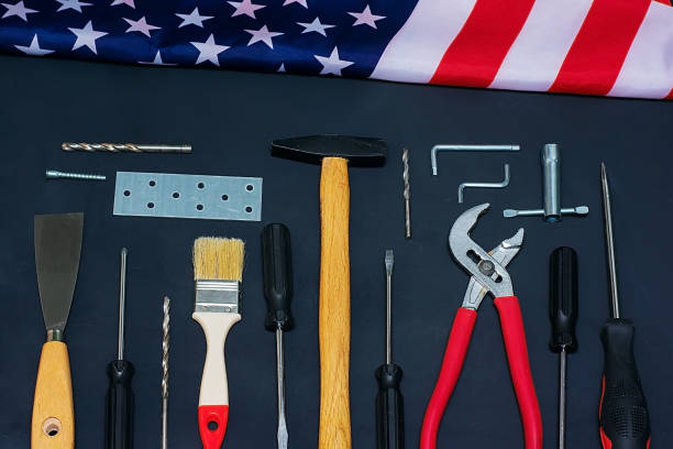 istock USA Labor Day. Different tools and american flag on a black background 1204024107