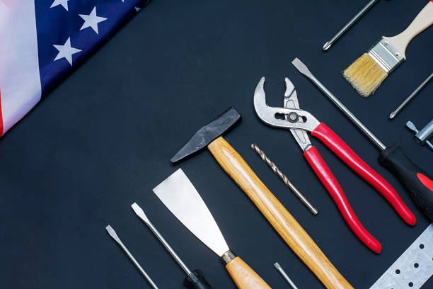 istock USA Labor Day. Different tools and american flag on a black background 1204025477