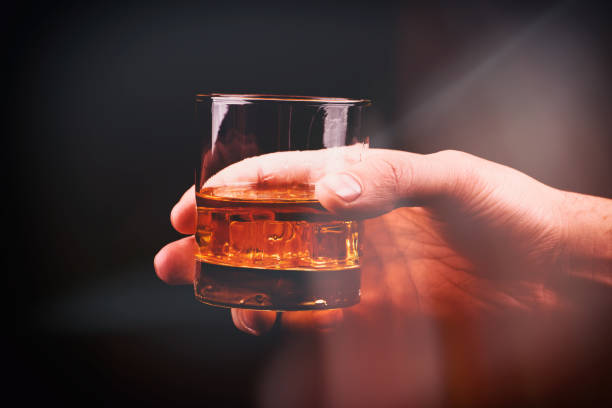 istock Whiskey glass in a hand of a man 1204025636