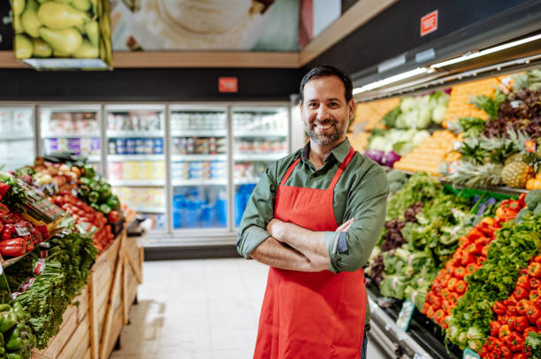 portrait fo latino employee in supermarket - reduction looking at camera finance business imagens e fotografias de stock