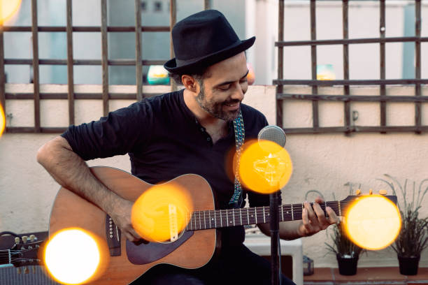 male guitarist performing on a rooftop at spring season. - jam up imagens e fotografias de stock