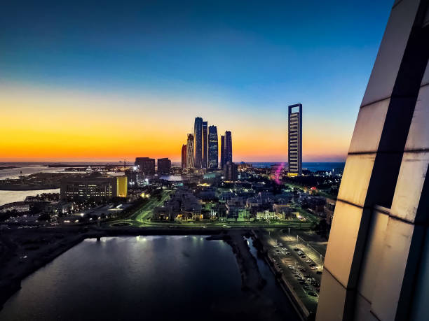 青い時間にダウンタウンのアブダビのスカイラインビュー - abu dhabi united arab emirates corniche city ストックフォトと画像