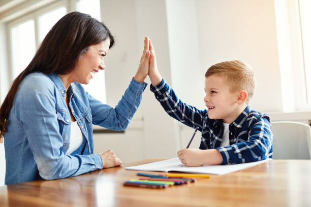 homework teaching boy high five education mother children son familiy childhood - homework imagens e fotografias de stock