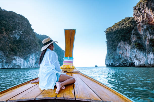 mujer que viaja en barco de cola larga, phangnga bay tailandia océano, famoso por sus muchas islas y laguna en el océano - phuket province beach blue cliff fotografías e imágenes de stock