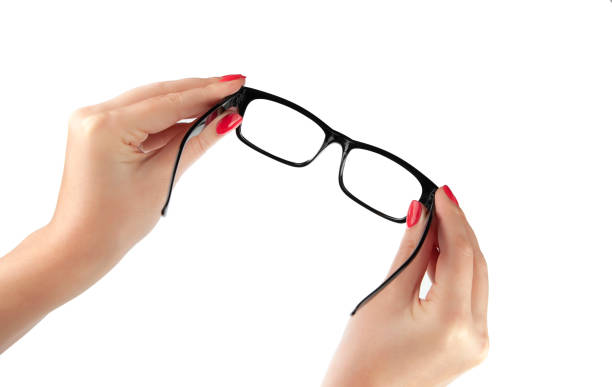 istock Female hand holding a black-framed glasses isolated on white background 1204030982