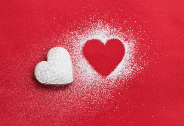 heart cookie and heart shaped candy on red background