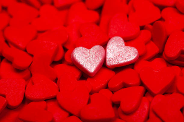 istock Two sweet hearts among many red hearts 1204031817