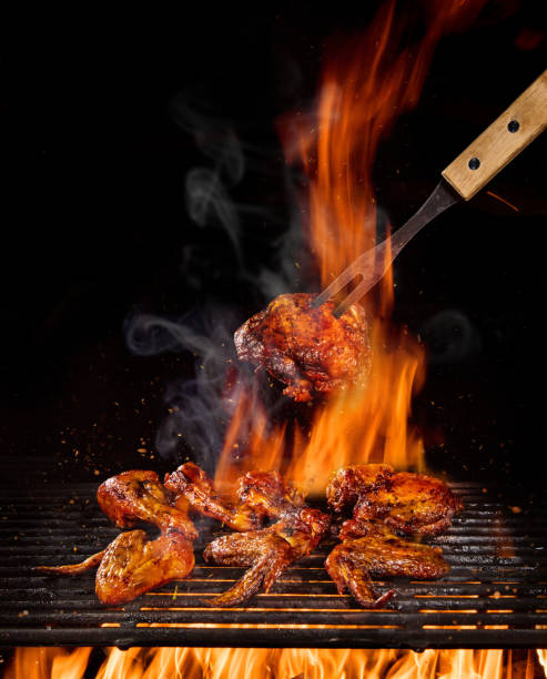 istock Chicken legs and wings on the grill with flames 1204031873
