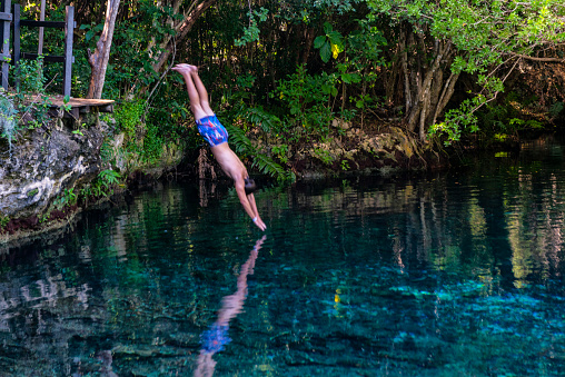 Boy jumping into a lagoon