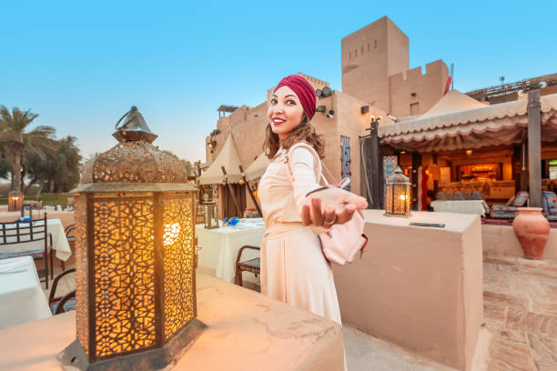 Follow happy woman traveler wearing dress and turban walking through the streets of an old Arab town or village in the middle of the desert. Concept of tourism and adventure alone Follow happy woman traveler wearing dress and turban walking through the streets of an old Arab town or village in the middle of the desert. Concept of tourism and adventure alone moroccan woman stock pictures, royalty-free photos & images