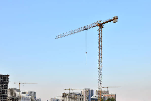istock Tower cranes at construction site in the sunset sky background 1204032506
