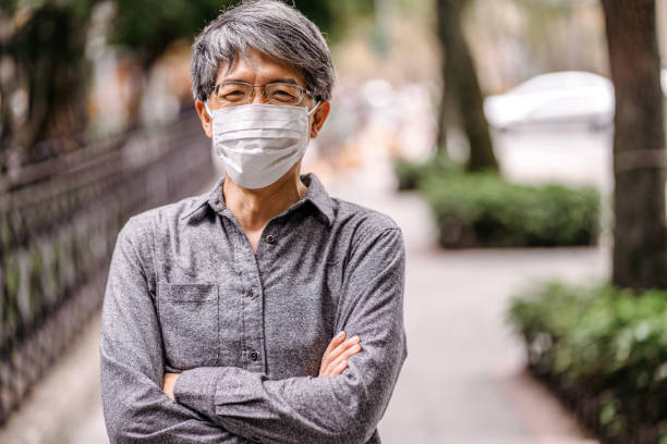 istock Mature gray-haired Taiwanese man with pollution mask 1204033831