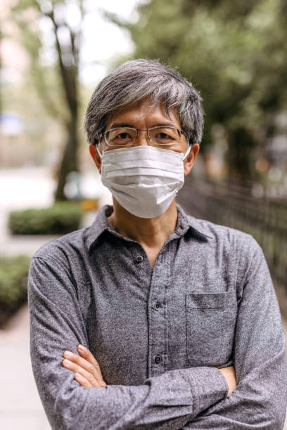istock Mature gray-haired Taiwanese man with pollution mask 1204033834