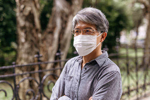 istock Mature gray-haired Taiwanese man with pollution mask 1204033870