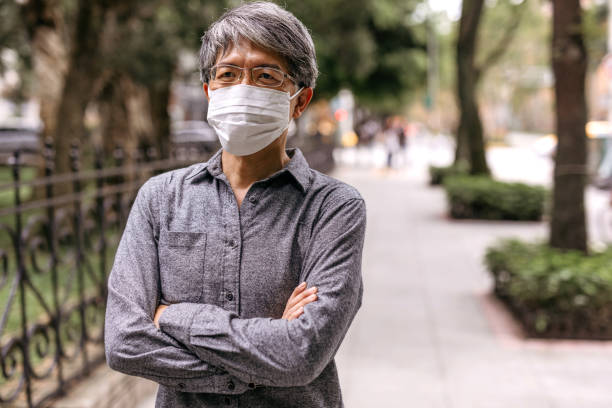 istock Mature gray-haired Taiwanese man with pollution mask 1204033901