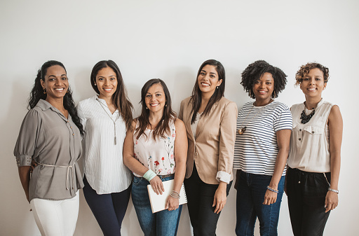 Group of women at office, posing for business portrait. Looking at camera.