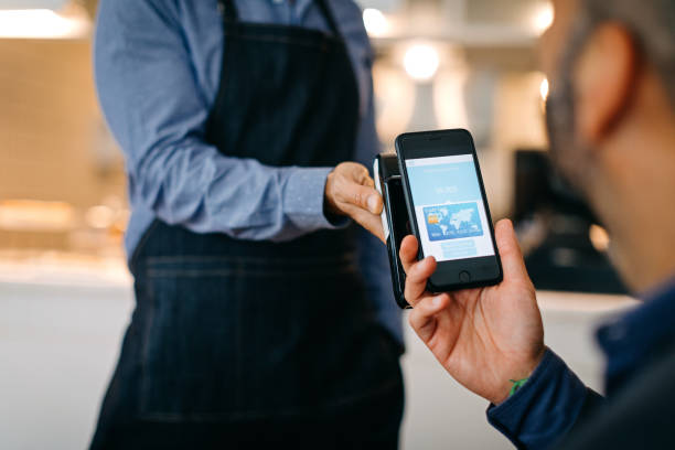 istock Businessman paying with smart phone in cafe 1204038012