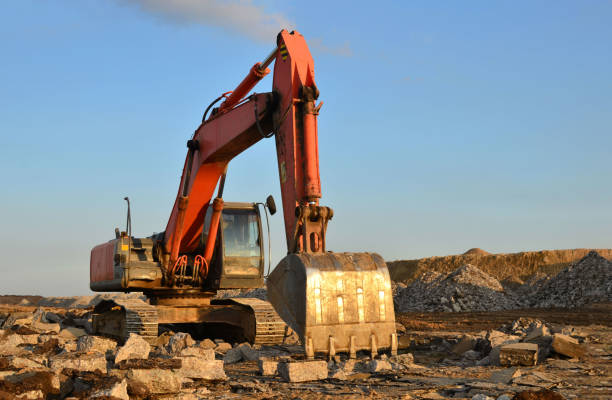istock Excavator load stone, old asphalt or concrete waste into a mobile jaw crusher machine 1204038861