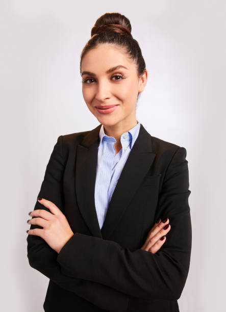 istock Confident young businesswoman smiling while standing against a gray background 1204041498