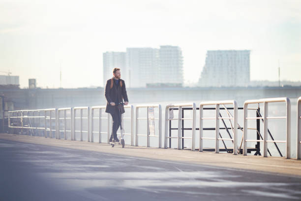 istock Young businessman on e scooter in the city 1204043896