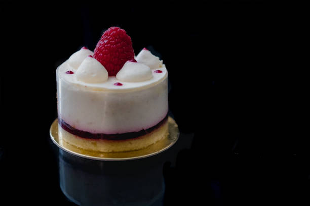 istock Luxury white cheesecake mousse cake decorated with fresh raspberries on a dark background. Flat lay. Close-up. Copy space 1204044961