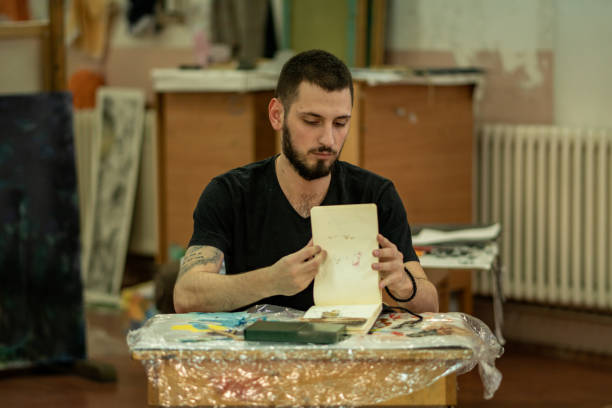istock Male artist drawing  in his sketch book 1204046115