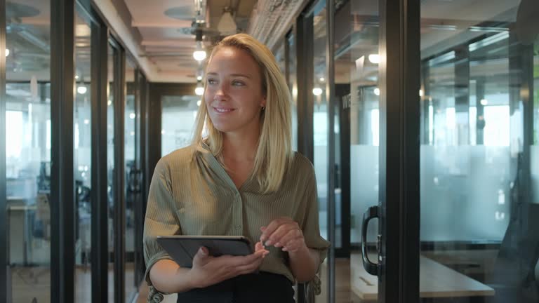 Young Businesswoman Walking with Digital Tablet in Office