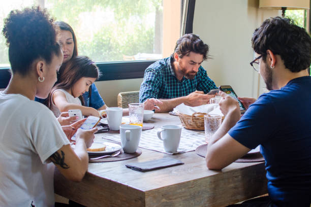 istock Modern family absorbed by technology during breakfast 1204049594