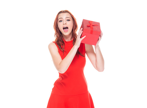 One person of aged 18-19 years old who is beautiful with redhead caucasian young women wearing dress and high heels who is cheerful and holding gift box