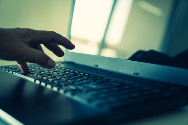 hacker or cyber crime hand reaching, stealing information on laptop, attack signifying internet theft while using online banking, anonymous business in technology internet and networking concept