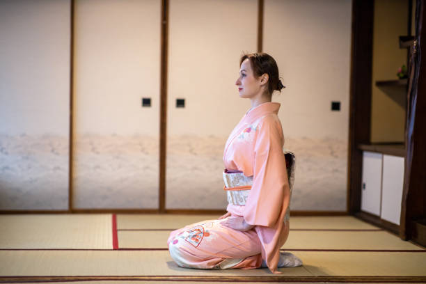 일본 다다미 방에서 발 뒤꿈치에 앉아 기모노러시아 여성의 측면보기 - service tokyo prefecture japan space 뉴스 사진 이미지