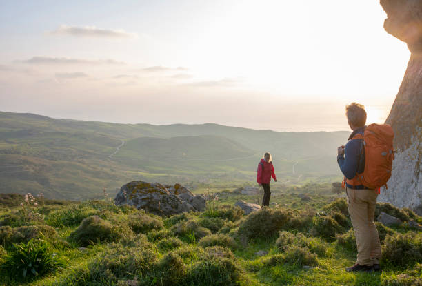 istock Hiking couple relax in meadow, below rock bluff 1204060486