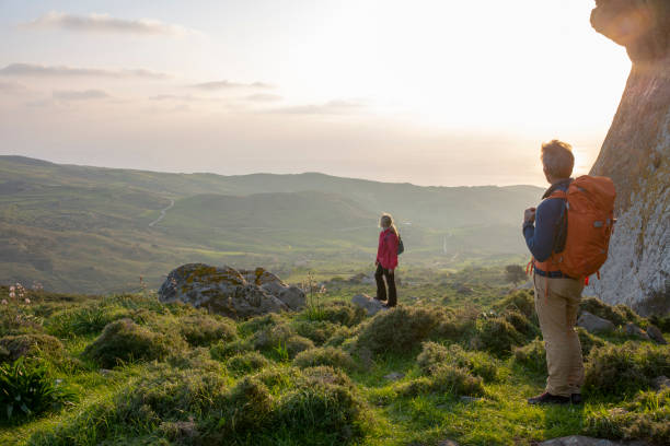istock Hiking couple relax in meadow, below rock bluff 1204060518